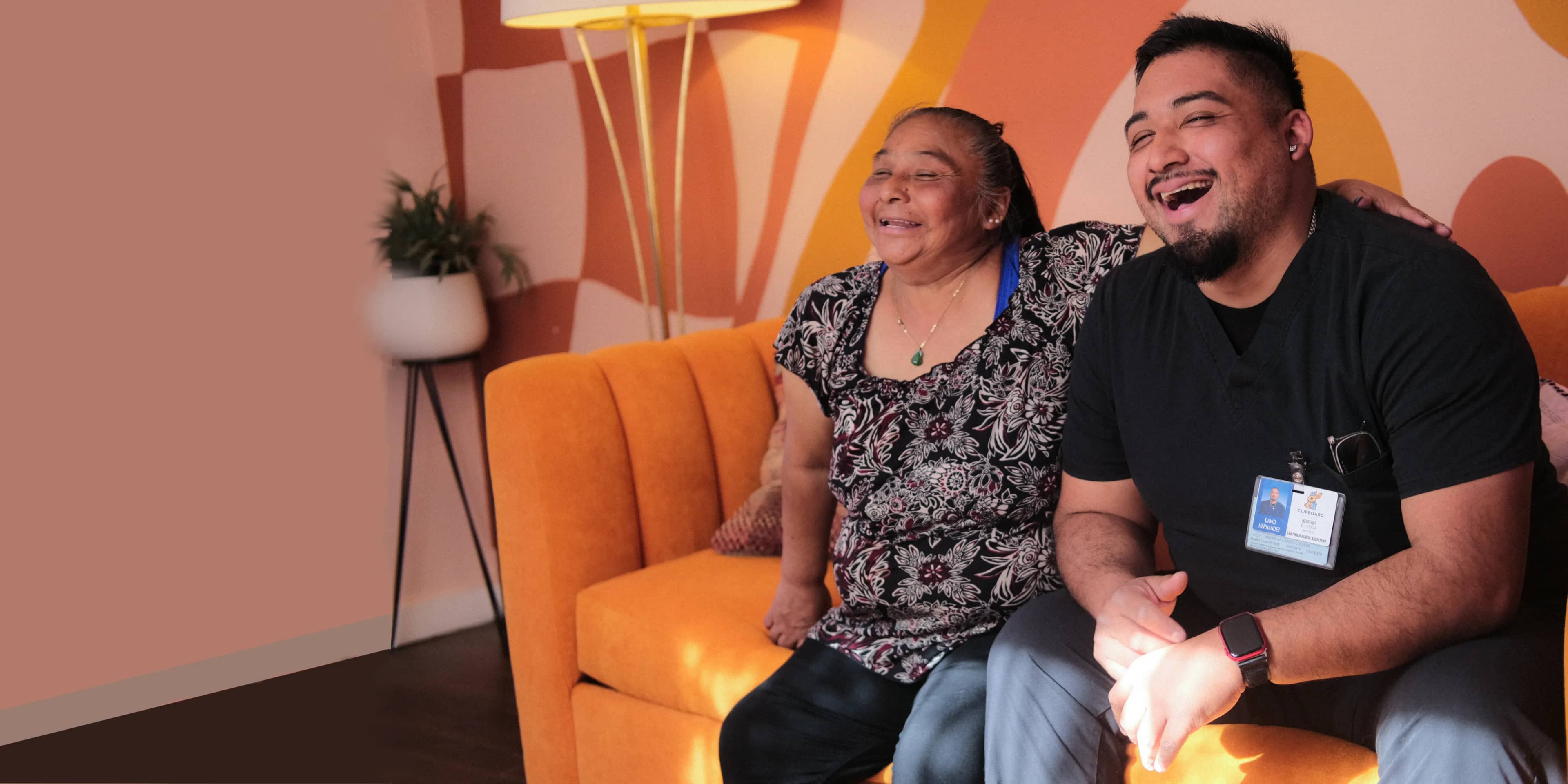 A CNA sits with a smiling patient